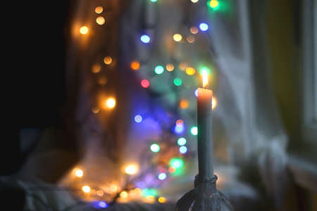 Lit candle and beautiful colorful bokeh lights. Selective focus.の写真素材