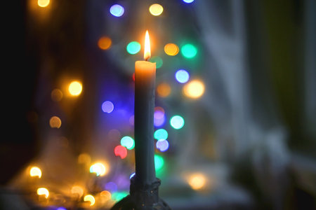 Lit candle and beautiful colorful bokeh lights. Selective focus.の写真素材