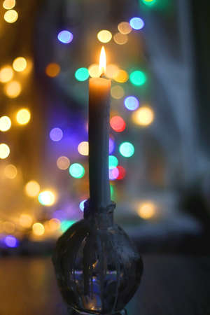 Lit candle and beautiful colorful bokeh lights. Selective focus.の写真素材