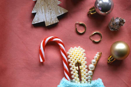 Pastel colored stocking filled with small presents and Christmas decorations. Pink background, flat lay.の写真素材