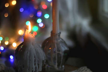 Lit candle and beautiful colorful bokeh lights. Selective focus.の写真素材