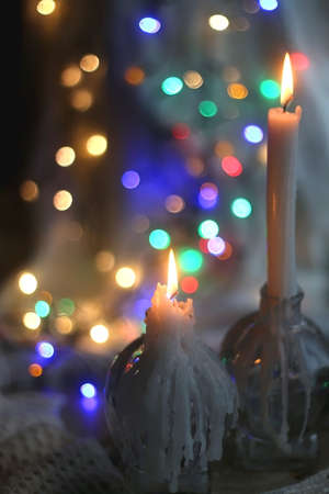 Lit candle and beautiful colorful bokeh lights. Selective focus.の写真素材