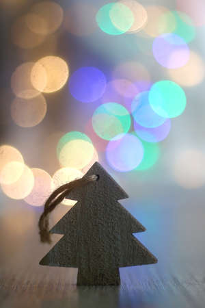 Wooden Christmas tree ornament on the table and colorful bokeh lights. Selective focus.の写真素材