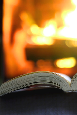 Open book in front of a fireplace. Selective focus.の写真素材