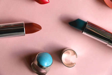 Various lipsticks, pink blush and silver rings on bright pink background. Flat lay.の写真素材