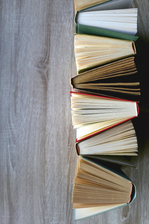 Bunch of vintage hardcover books on wooden background. Top view.