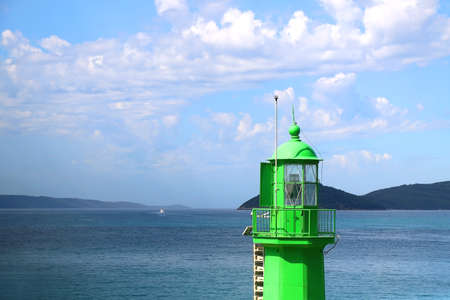 Green lighthouse in the port of Split, Croatia and bright blue sky.の写真素材