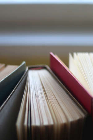 Bunch of vintage hardcover books on wooden background. Selective focus.の写真素材