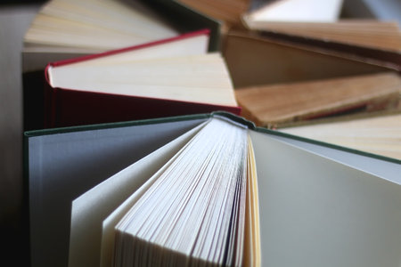 Bunch of vintage hardcover books on wooden background. Selective focus.の写真素材