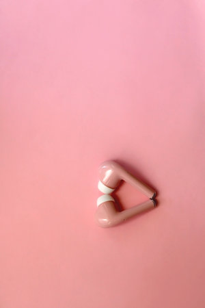 Pink wireless  earphones on pink background. Flat lay.
