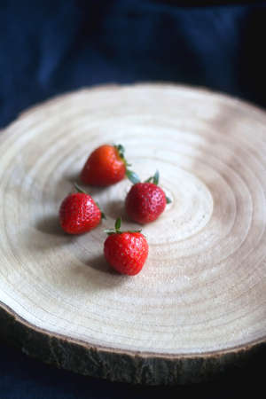Wooden tray with small homegrown strawberries. Selective focus.の写真素材