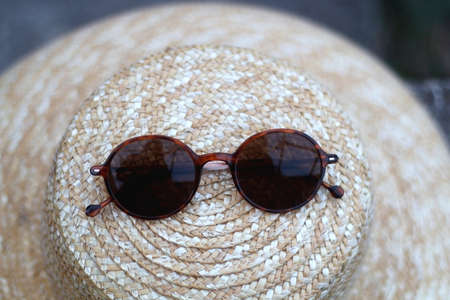 Straw hat and retro tortoiseshell pattern sunglasses. Selective focus.の写真素材