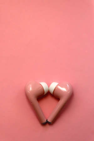Pink wireless  earphones on pink background. Flat lay.の写真素材