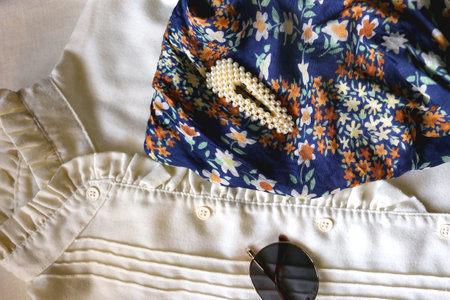 Vintage white blouse, floral scarf, round sunglasses, gold rings and pearl hair barrettes. Flat lay.の写真素材