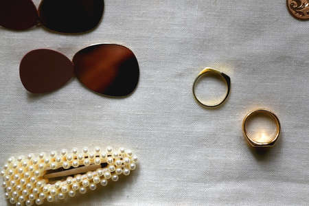 Various gold jewelry, personal accessories and beauty products on neutral background. Flat lay.の写真素材