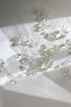 Various transparent beads on white background, illuminated by sunlight and reflectiing light....
