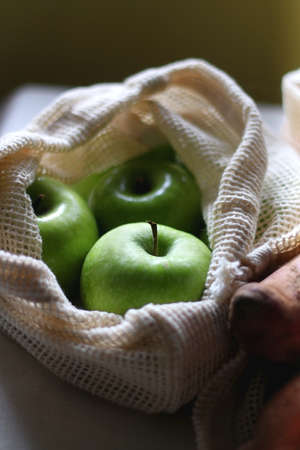 Reusable mesh bags filled with various healthy fruit and vegetable. Selective focus.の写真素材