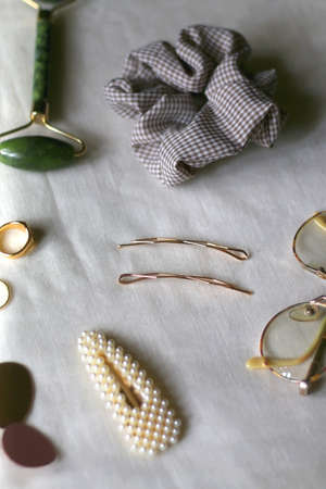 Various gold jewelry, personal accessories and beauty products on neutral background. Selective focus.の写真素材