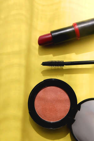 Lipstick, mascara and blush on bright yellow background. Flat lay.の写真素材