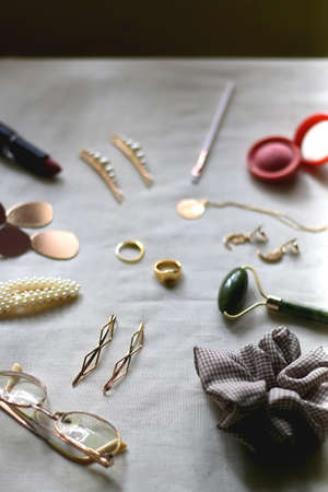 Various gold jewelry, personal accessories and beauty products on neutral background. Selective focus.の写真素材