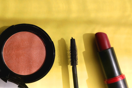 Lipstick, mascara and blush on bright yellow background. Flat lay.の写真素材