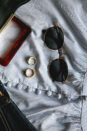 Striped blouse, denim skirt, sunglasses, gold rings, fashionable bag and green headband. Flat lay.の写真素材