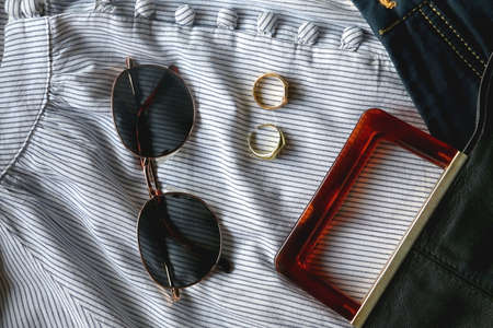 Striped blouse, denim skirt, sunglasses, gold rings, fashionable bag and green headband. Flat lay.の写真素材