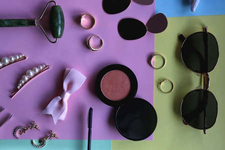 Various accessories, make up products and jewelry on various colorful pastel backgrounds. Flat lay.の写真素材