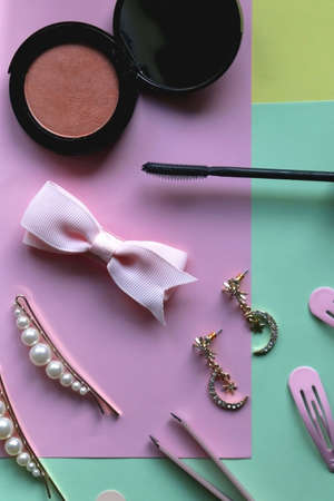 Various accessories, make up products and jewelry on various colorful pastel backgrounds. Flat lay.の写真素材