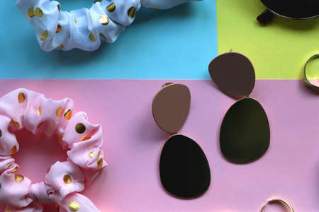 Various accessories, make up products and jewelry on various colorful pastel backgrounds. Flat lay.の写真素材