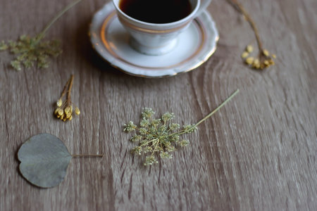 Cup of tea and pressed flowers on wooden table. Selective focus.の写真素材