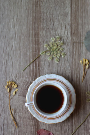 Cup of tea and pressed flowers on wooden table. Top view.の写真素材