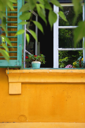 Traditional Mediterranean window with green shutters and bright yellow wall. Picturesque architecture in Split, Croatia.の写真素材