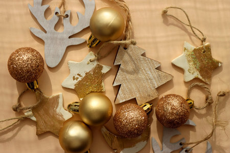 Christmas tree ornaments in neutral and gold colors, illuminated by sunlight. Flat lay.の写真素材