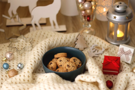 Various Christmas decorations, cup of tea or coffee, sweets, small presents, knitted blanket and candles. Selective focus.の写真素材