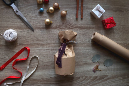 Christmas present wrapped in recycled paper, with various craft supplies and Christmas decorations...