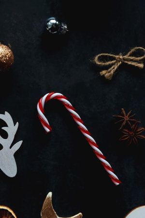 Small presents, various Christmas ornaments and deer figurine on dark background. Top view.