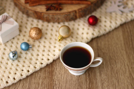 Various Christmas decorations, cup of tea or coffee, sweets, small presents, knitted blanket and candles. Selective focus.の写真素材