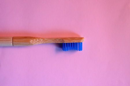 Sustainable wooden toothbrush on pastel pink background. Top view.の写真素材