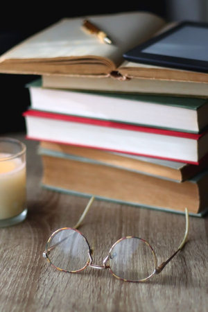 <p>Pile of books, tablet, reading glasses, mobile phone, scented candle, pen and laptop on the table. Selective focus.</p>の写真素材