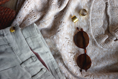 Vintage sweater, neutral trousers, wicker bag, leopard scarf, brown shoes, sunglasses and brass...