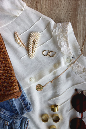 White blouse, denim skirt, vintage bag, sunglasses, pearl barrettes and gold jewelry. Top view.
