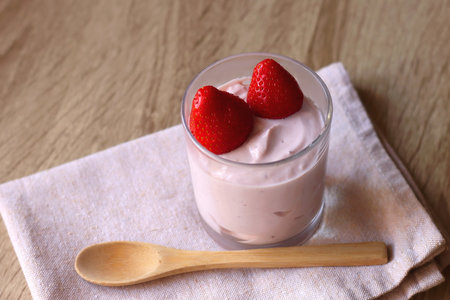 Bowl of strawberry yogurt with two fresh strawberries on the top. Selective focus.の写真素材