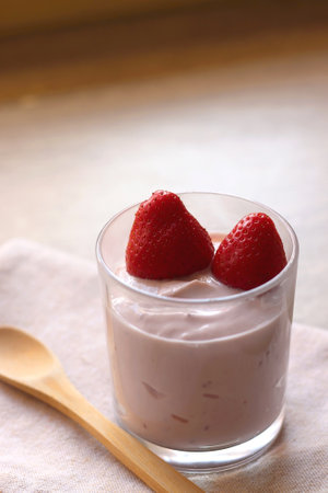 Bowl of strawberry yogurt with two fresh strawberries on the top. Selective focus.の写真素材