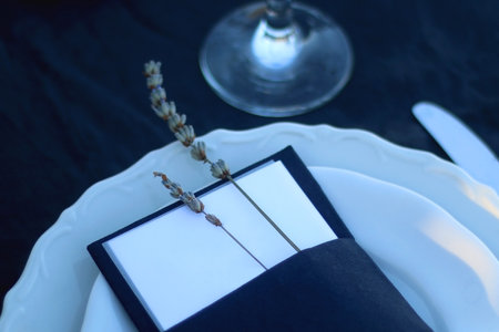Table setting with white and blue dishes, candles and lavender flowers. Rustic Mediterranean style. Selective focus.の写真素材