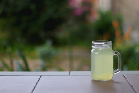 Glass of lemonade served in the garden. Selective focus.の写真素材