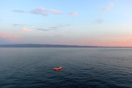 Beautiful sunset over the Adriatic Sea. Small old fashioned fishing boat at the sea.