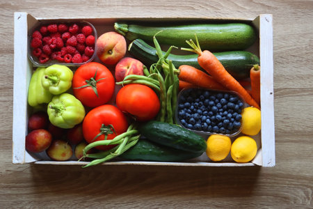 Wooden crate full of healthy seasonal fruit and vegetable. Top view, wooden background.の写真素材