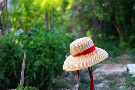 Straw hat hanging in the garden. Selective focus.の写真素材
