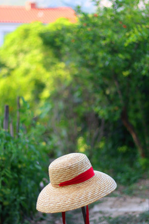 Straw hat hanging in the garden. Selective focus.の写真素材